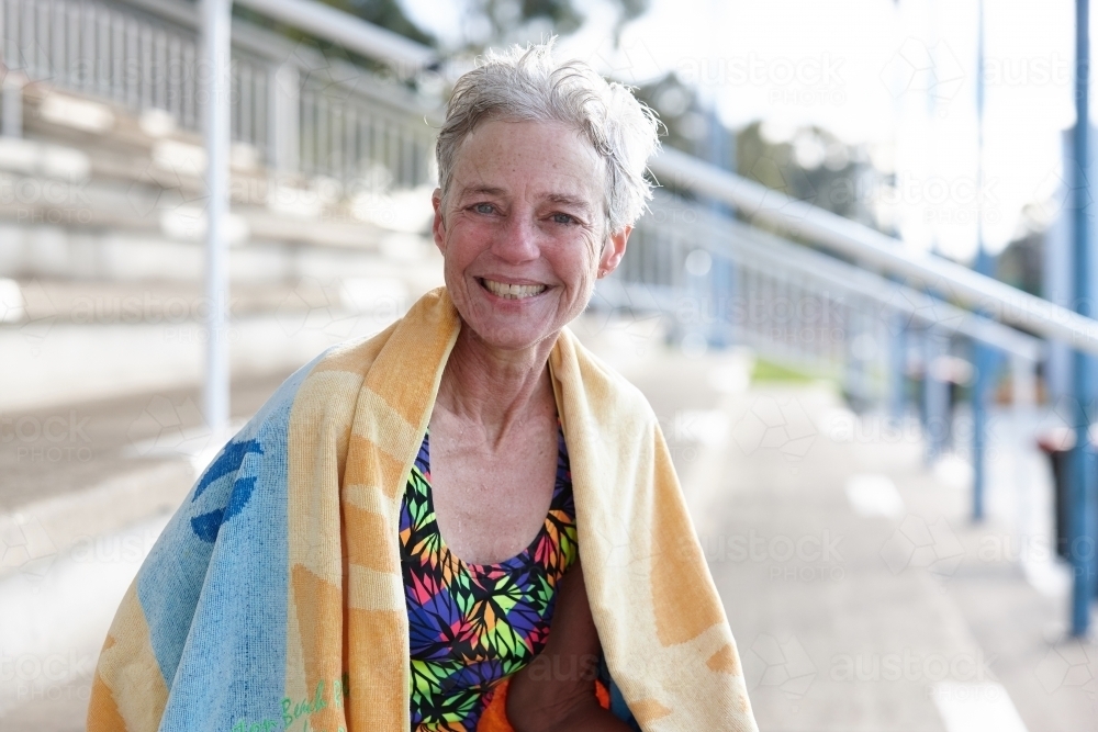 Active senior lady with towel at swimming pool - Australian Stock Image