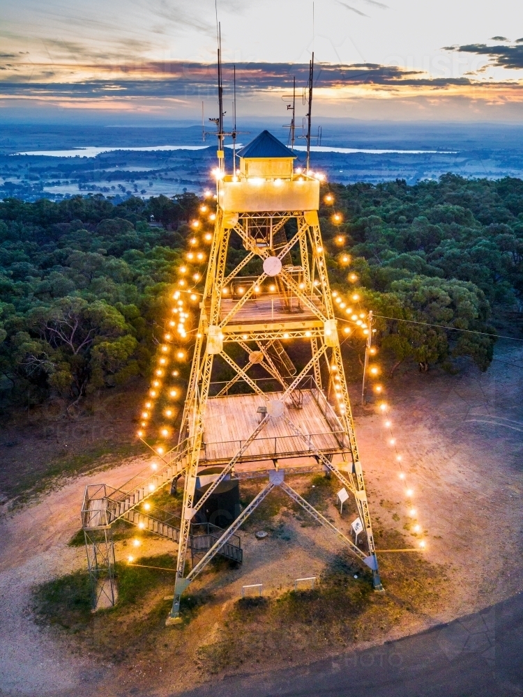 Aerial view of a poppet head tower decorated with lights at sunset - Australian Stock Image