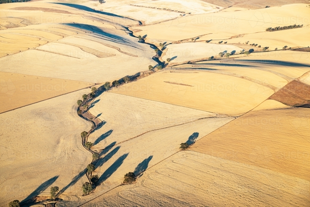 aerial view of creek winding through farmland - Australian Stock Image