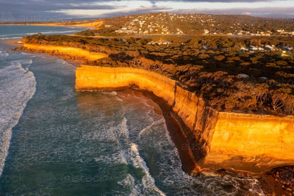 Aerial view of high coastal cliffs catching golden dawn side lighting - Australian Stock Image