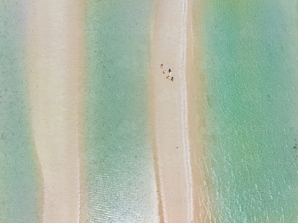 Aerial view of people walking on a narrow sandy  beach between pools of clear water - Australian Stock Image