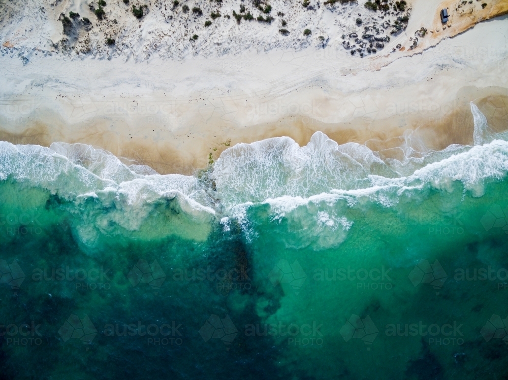 aerial view of waves washing up onto a beach - Australian Stock Image
