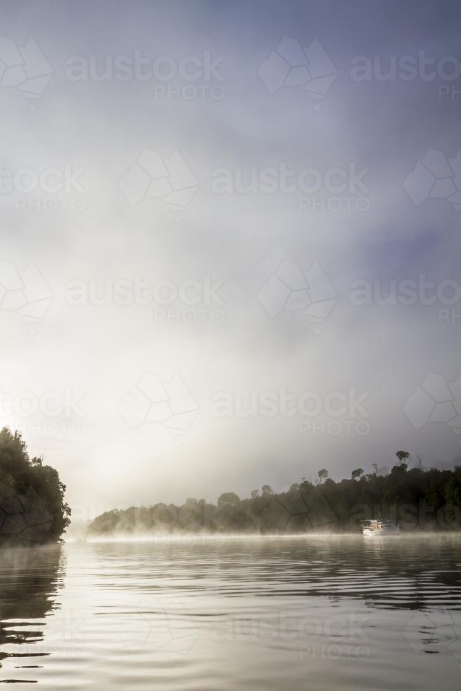Beautiful old wooden boat on the water in fog - Australian Stock Image