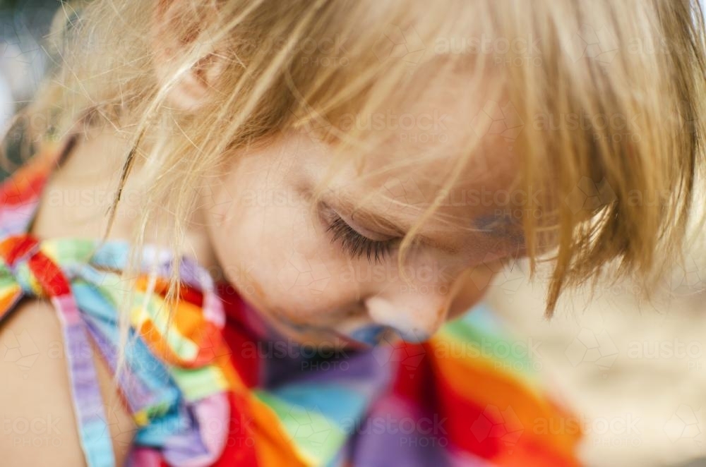 Close up of little girl in a rainbow dress - Australian Stock Image