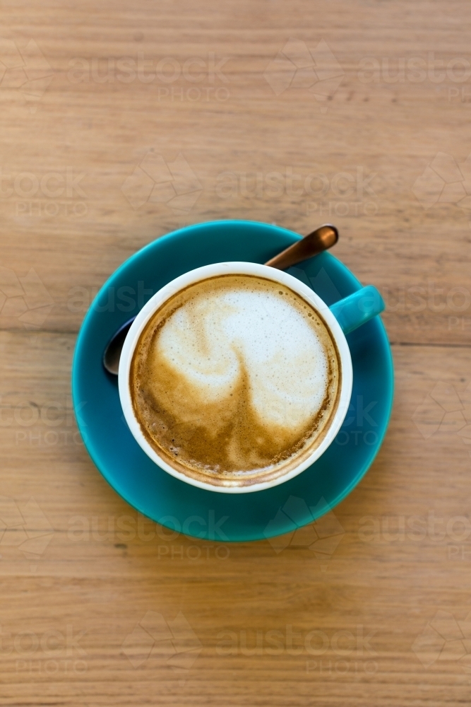 Coffee in cup on wooden table top down view - Australian Stock Image