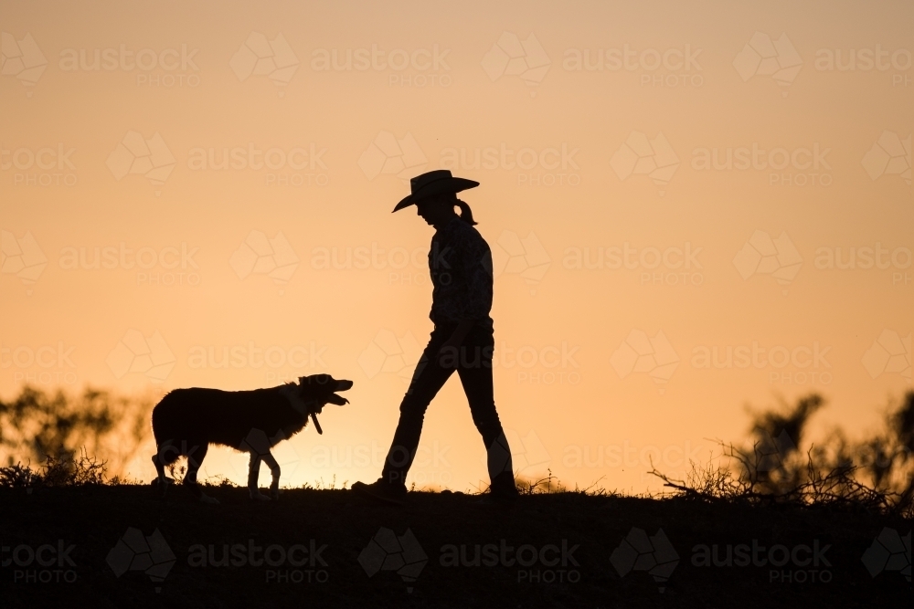 Cowgirl and dog silhouette - Australian Stock Image