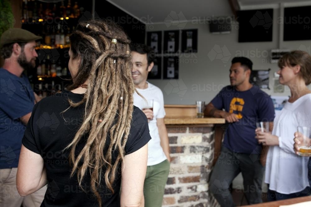 Customers standing having a drink at local pub - Australian Stock Image