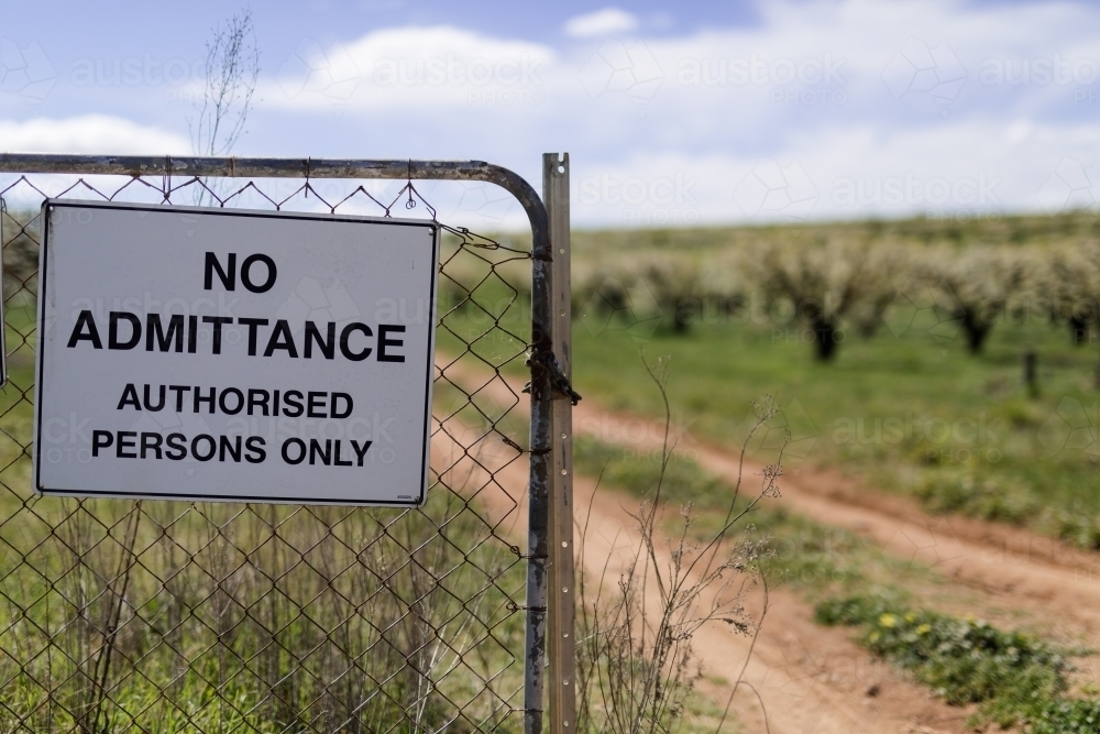 danger and keep out signs on an orchard gate - Australian Stock Image
