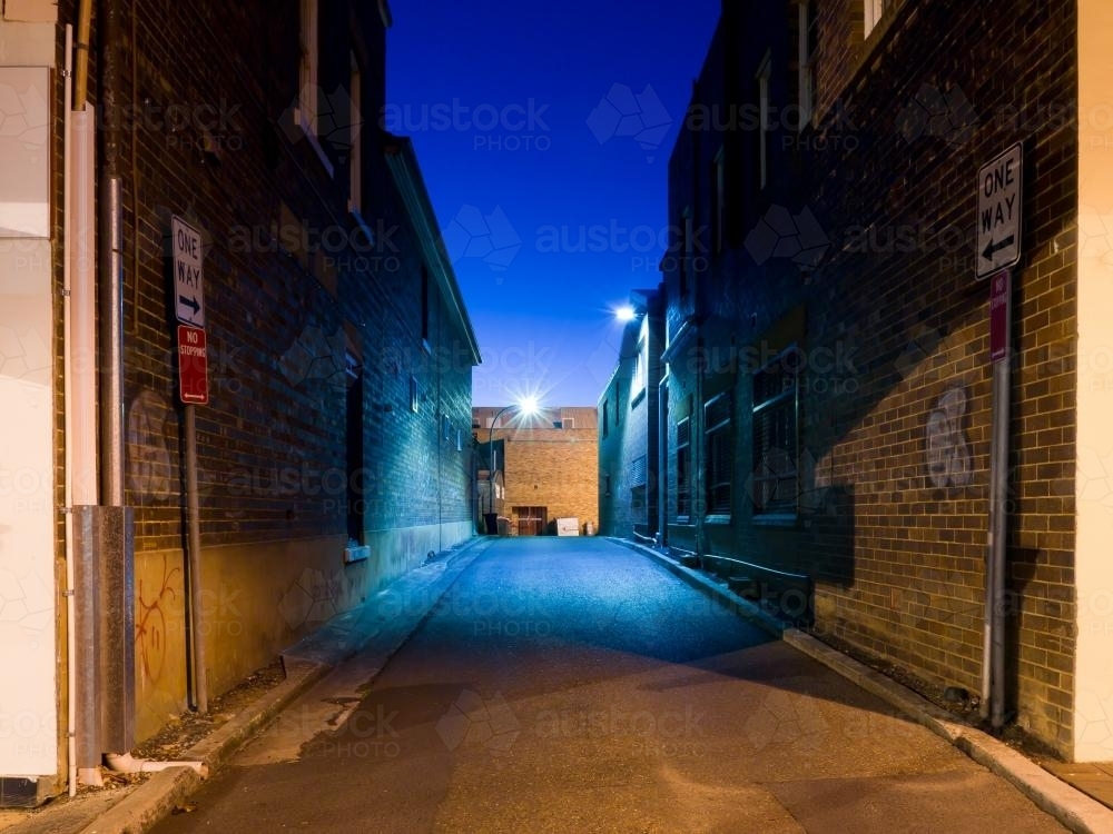 Evening shot of an one way alleyway with blue light and sky - Australian Stock Image