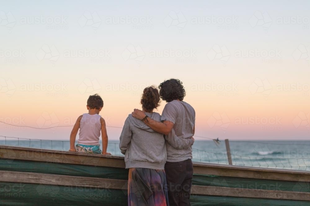 Family watching the sunset at the beach - Australian Stock Image