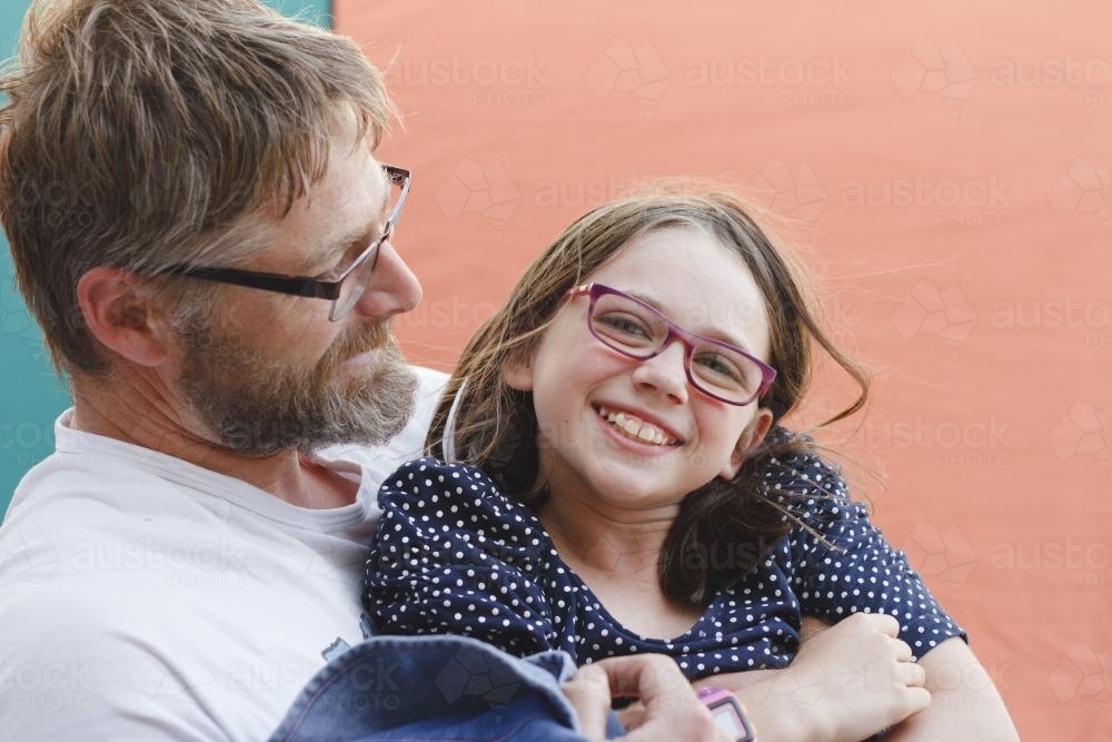 Father holding smiling daughter - Australian Stock Image