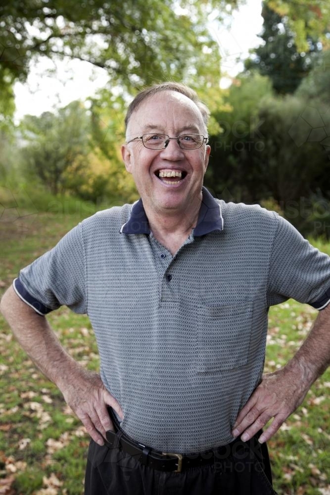 Laughing man with disability standing outside with hands on hips - Australian Stock Image