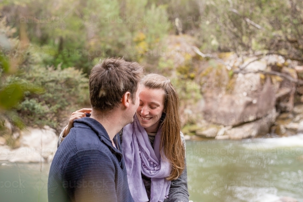 Man and woman in embrace overlooking river - Australian Stock Image