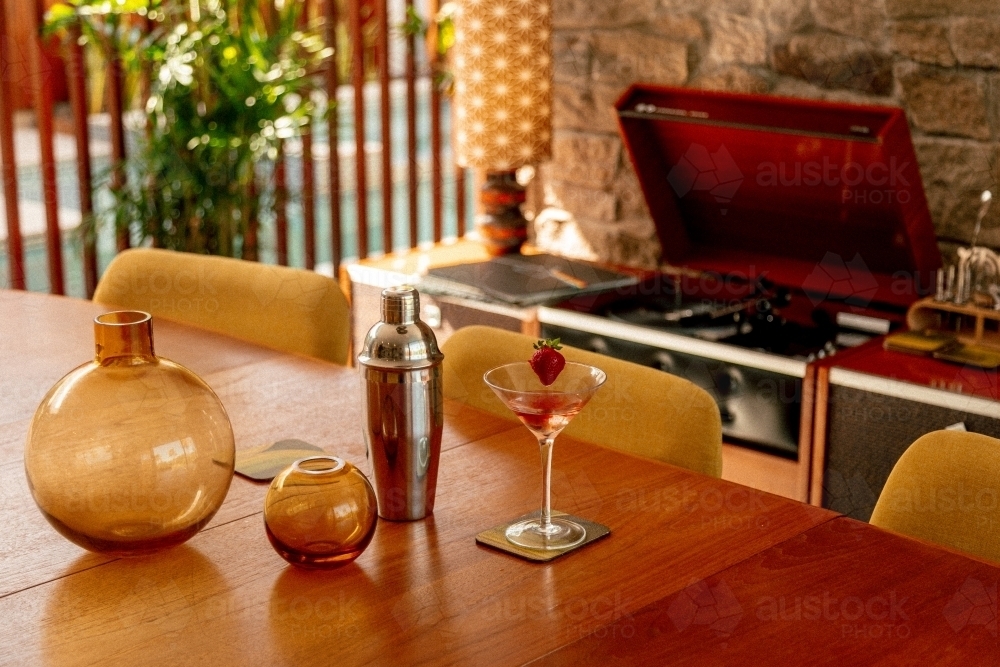 Martini Cocktail, Cocktail Shaker and Record Player on a Wood Table in a 70's Styled Home - Australian Stock Image