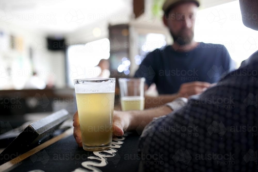 Men having a drink at the bar in a local craft beer pub - Australian Stock Image