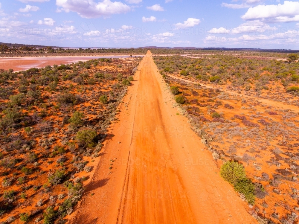 outback red dirt road disappearing to horizon - Australian Stock Image