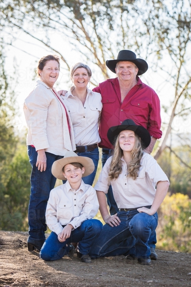 Parents with daughter and grandchildren wearing akubras on family property farm during drought - Australian Stock Image