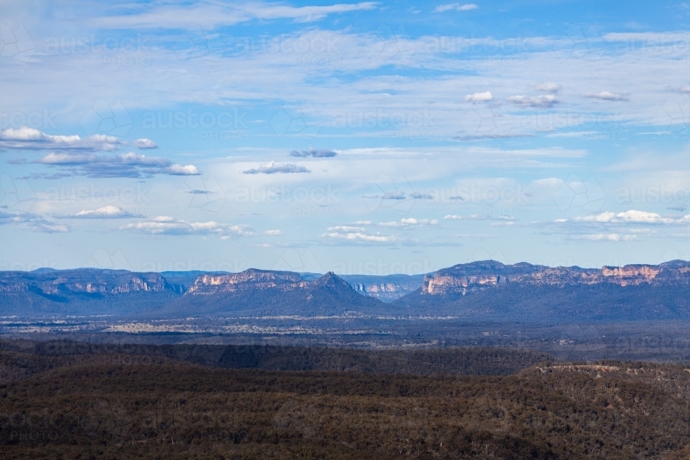 Pearsons Lookout view Over Capertee Valley with distant mountains over trees - Australian Stock Image
