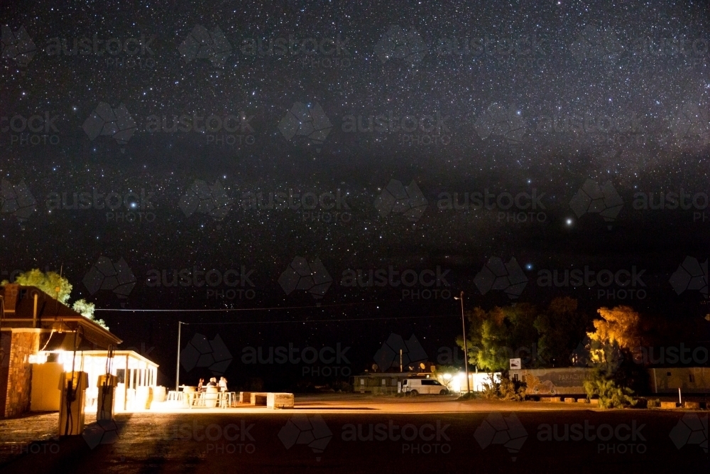 People outside hotel at night under a starry sky - Australian Stock Image