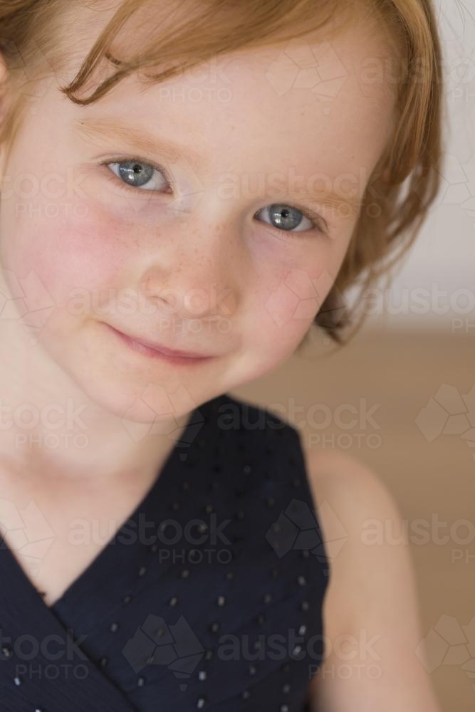 Portrait of a smiling young girl with red hair - Australian Stock Image