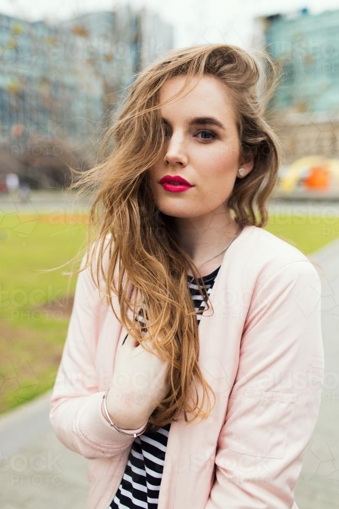 Portrait of fashionable young woman posing in a city park - Australian Stock Image
