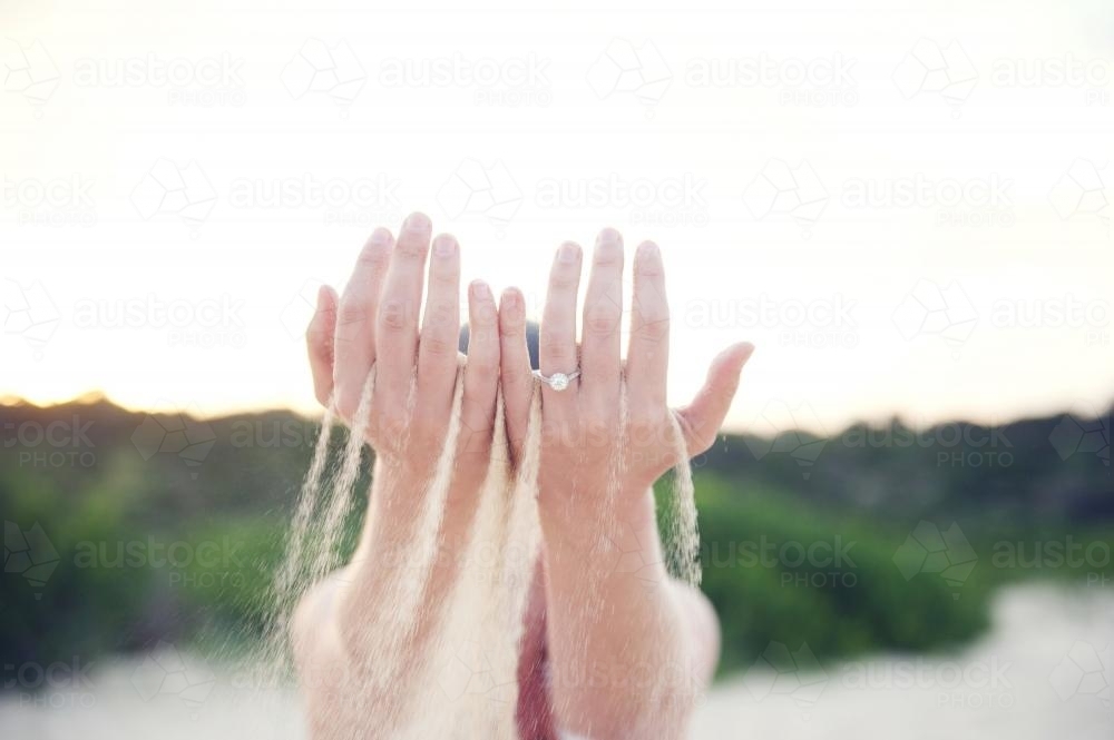 Sand cascading through fingers - Australian Stock Image