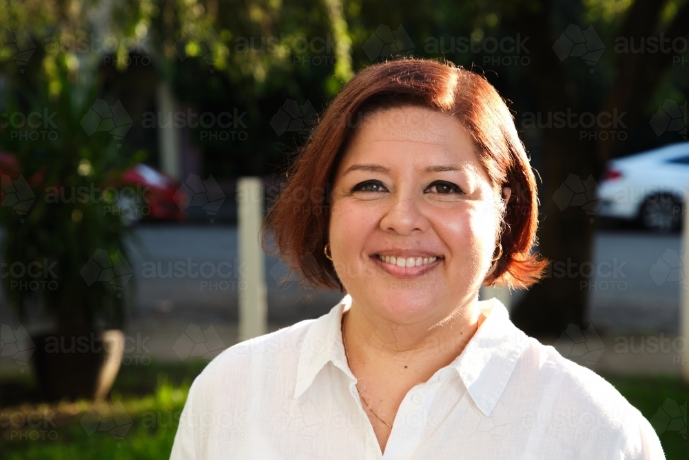 Smiling middle aged woman with a short hair wearing white shirt - Australian Stock Image