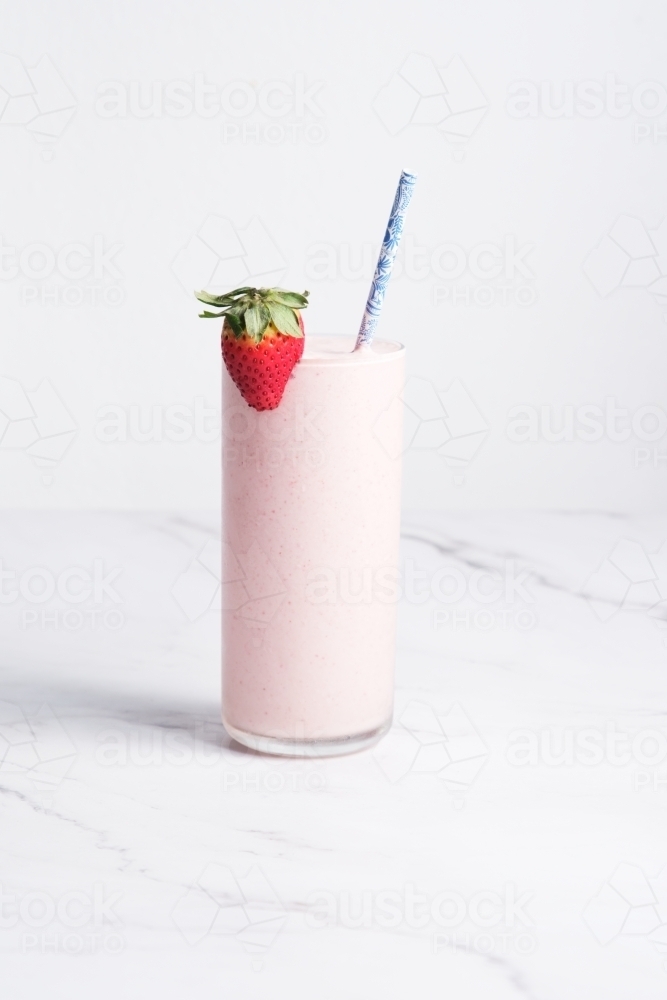Strawberry milkshake with straw and fresh strawberry - Australian Stock Image