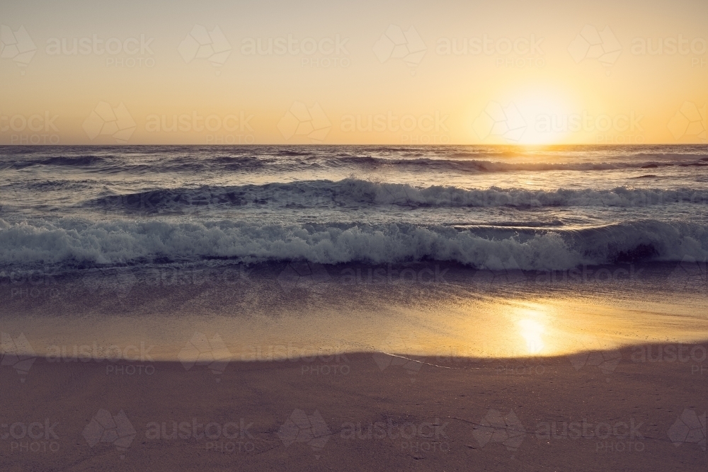Sunrise over breaking waves - Australian Stock Image