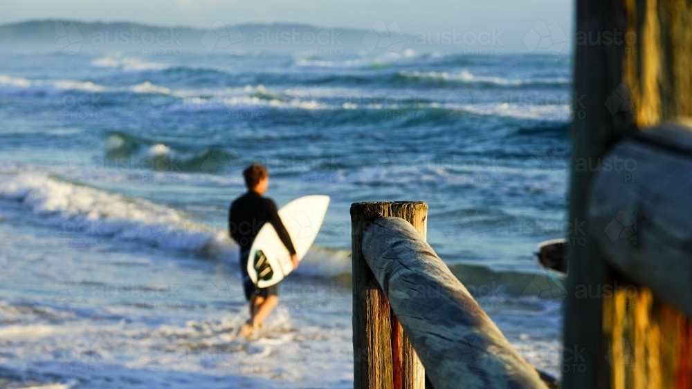 Surfer with board entering the water - Australian Stock Image