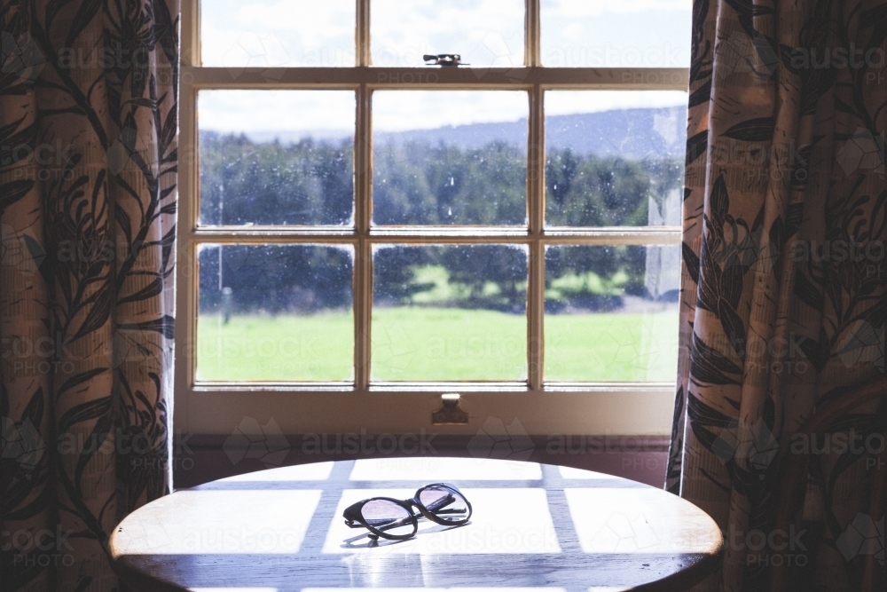 Table in front of window overlooking country landscape - Australian Stock Image