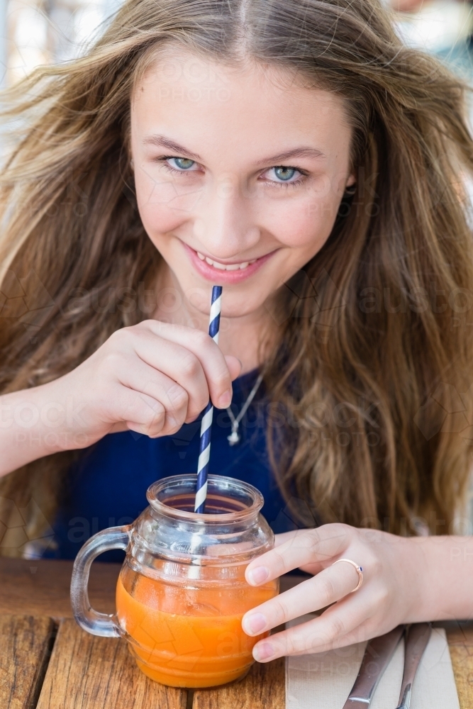 teen with fruit drink in a cafe - Australian Stock Image