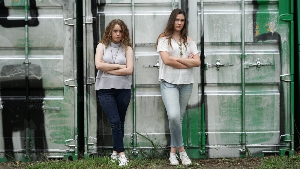 Teenage girls standing in front of container graffiti - Australian Stock Image