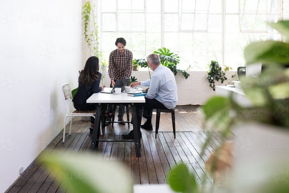 Three people collaborating in an open office - Australian Stock Image