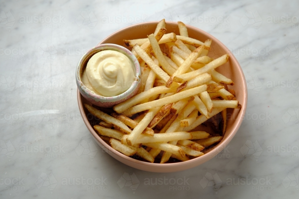 Top shot of french fries with mayonnaise in a pink bowl - Australian Stock Image
