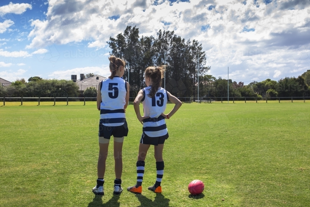 Two girl AFL players standing on the football ground - Australian Stock Image