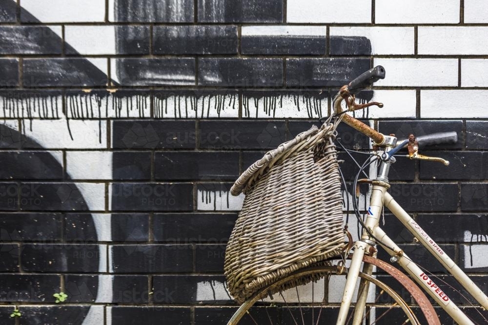 Vintage bike against wall with painted lettering - Australian Stock Image