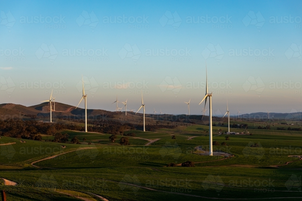 wind turbines in rolling landscape at dusk - Australian Stock Image