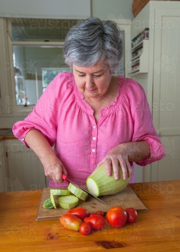 Woman cutting vegetables - Australian Stock Image
