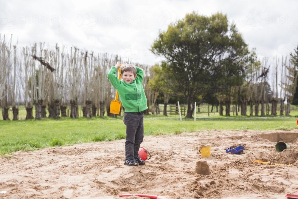 Young boy playing in sandpit - Australian Stock Image