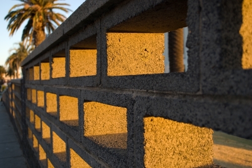 A cinder block brick wall bathed in golden light