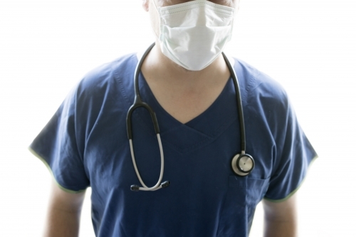 A nurse or doctor wearing scrubs, a facial mask and a stethascope