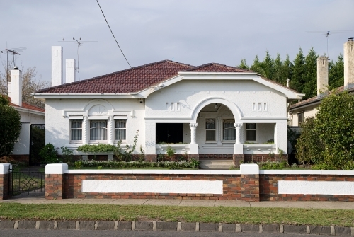 A white California bungalow style house from the street
