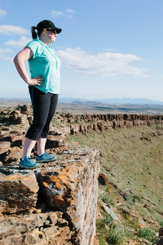 A woman in hiking gear overlooking the rugged landscape of the Flinders Ranges