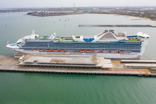 Aerial view of a large cruise ship docked at shipping terminal