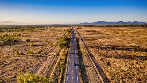 Aerial view of bush land and a  car on the highway in Mount Morgan during day time