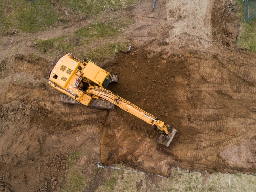 Aerial view of digger on house build construction site
