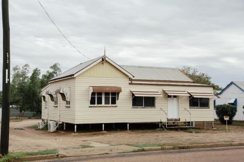 Australian Queenslander cream coloured house with brown trimming