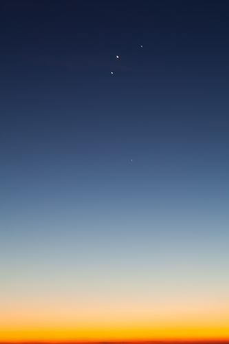 Blue and yellow dawn sky with planets aligned