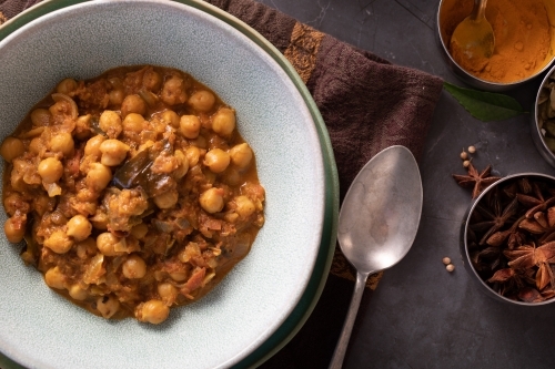 Bowl of Chickpea Curry with spices around